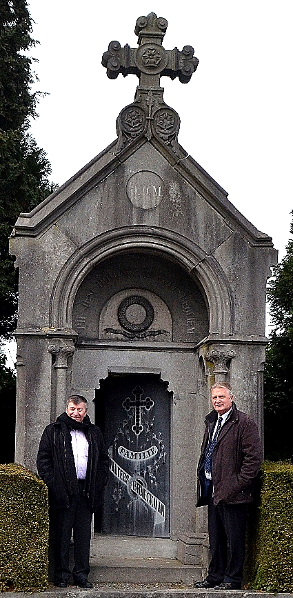 Burgemeester Luc De Ryck en schepen Hugo Maes, bevoegd voor begraafplaatsen, poseren aan de grafkapel van Wauters-Braeckman.